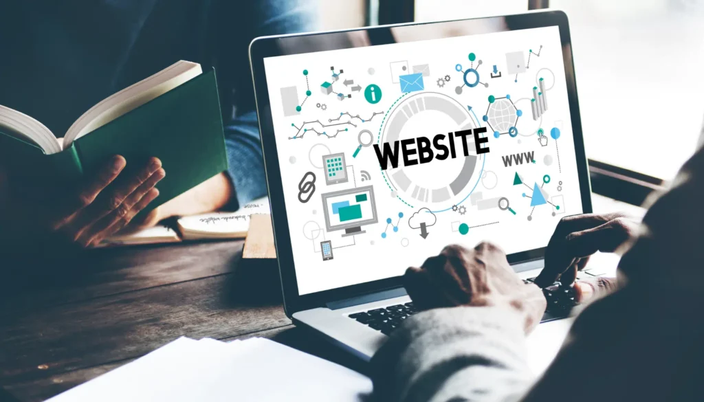 A person typing on a laptop displaying the word "WEBSITE," surrounded by digital icons, while holding a green book — representing the importance of website accessibility for business.
