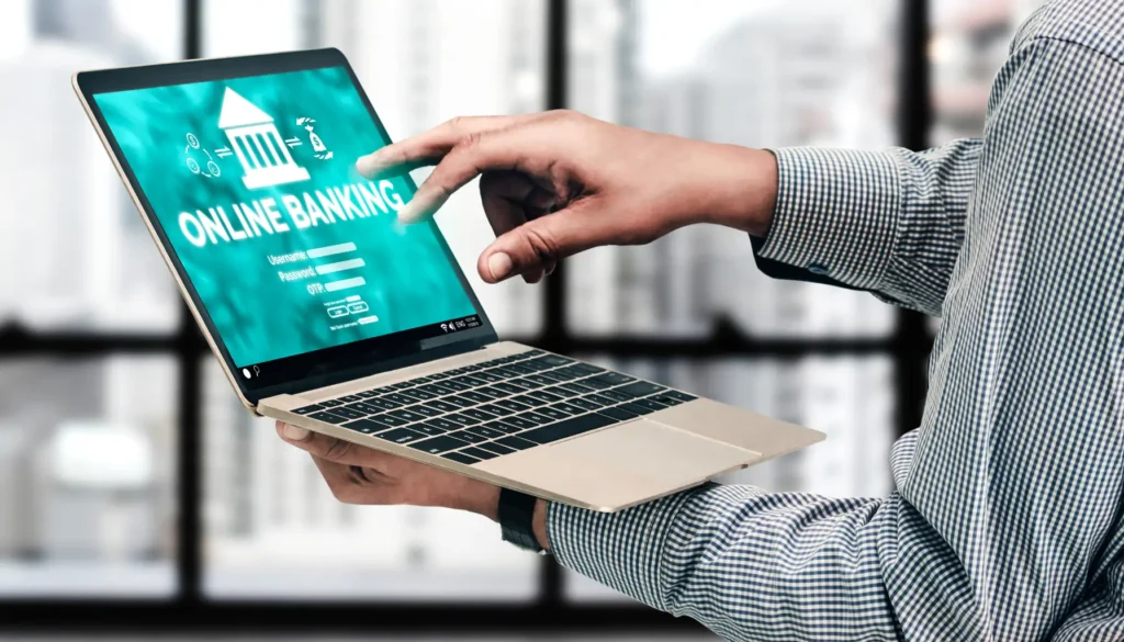 A person interacts with a laptop displaying a disabled friendly online banking login page, emphasizing digital finance services.